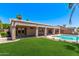 Gorgeous backyard with a manicured lawn, covered patio, and sparkling pool that's perfect for entertaining at 4940 S Rosemary Dr, Chandler, AZ 85248