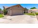 Beige single-story home showcasing a two-car garage, tile roof, manicured lawn, and mature landscaping at 4940 S Rosemary Dr, Chandler, AZ 85248
