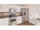 Updated kitchen with stainless steel appliances, granite countertops, white cabinets and mosaic backsplash at 4940 S Rosemary Dr, Chandler, AZ 85248