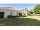 Landscaped front yard featuring a well-maintained lawn and lush greenery, with a charming single-story home in the background at 541 E Spur Ave, Gilbert, AZ 85296