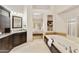 The main bathroom features a soaking tub, dark cabinets, granite countertops, and access to bedroom at 541 E Spur Ave, Gilbert, AZ 85296