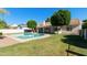 A well-maintained pool is surrounded by green grass and mature landscaping, enhancing this home's outdoor appeal at 541 E Spur Ave, Gilbert, AZ 85296