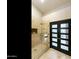 A modern shower featuring neutral tile, built-in niche, glass doors, and dark wood doors at 541 E Spur Ave, Gilbert, AZ 85296