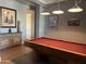 A game room featuring a red felt pool table, wood floors, and artwork on the wall at 5637 E Lonesome Trl, Cave Creek, AZ 85331