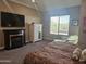 This main bedroom is highlighted by a fireplace, television, and large sunny windows with desert views at 5637 E Lonesome Trl, Cave Creek, AZ 85331