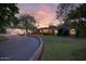 Charming single-story home with lush lawn, brick accents, and attached garage under a captivating sunset at 5818 N 3Rd Ave, Phoenix, AZ 85013