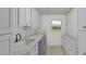 Well-appointed laundry room featuring marble countertops, custom cabinetry, and modern appliances at 8108 N Central Ave, Phoenix, AZ 85020