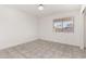 Minimalist bedroom with tile floors, a window for natural light, and a neutral color palette at 8339 W Elm St, Phoenix, AZ 85037