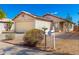 Inviting single-story home with desert landscaping, a two-car garage, and decorative details under a blue sky at 8339 W Elm St, Phoenix, AZ 85037