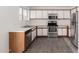 Bright kitchen with white cabinets, stainless steel appliances, and wood-look tile flooring for a contemporary feel at 8339 W Elm St, Phoenix, AZ 85037
