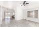 Open living room with tile floors, a ceiling fan, and a view of the kitchen and the backyard pool at 8339 W Elm St, Phoenix, AZ 85037