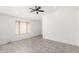 Well-lit living room featuring tile flooring, a ceiling fan, and a large window for natural light at 8339 W Elm St, Phoenix, AZ 85037