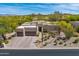 Beautiful aerial view of the home showcasing its desert landscaping, mature trees, and paver driveway at 9780 E Gamble Ln, Scottsdale, AZ 85262