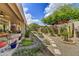 Lush backyard featuring a covered patio, mature trees, and colorful flowerbeds at 9780 E Gamble Ln, Scottsdale, AZ 85262
