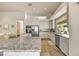 Modern kitchen with stainless steel appliances, granite countertops, white cabinetry, and large windows at 9780 E Gamble Ln, Scottsdale, AZ 85262