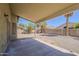 Exterior view of the covered patio of a house with a gravel backyard, and many trees outside the brick wall at 1079 E Jasper Dr, Gilbert, AZ 85296