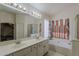 Bathroom featuring double sinks, a large mirror, and a separate tub and shower at 1079 E Jasper Dr, Gilbert, AZ 85296