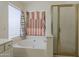 Bright bathroom features a shower with glass door and garden tub at 1079 E Jasper Dr, Gilbert, AZ 85296