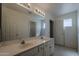 Bright bathroom featuring double sinks, a shower, and a window at 1079 E Jasper Dr, Gilbert, AZ 85296
