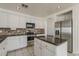 This kitchen boasts white cabinetry, stainless steel appliances, granite countertops, and a practical kitchen island at 1079 E Jasper Dr, Gilbert, AZ 85296