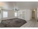 Spacious living room featuring a ceiling fan and built-in shelving for storage and display at 1079 E Jasper Dr, Gilbert, AZ 85296