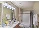 Well-lit bathroom featuring a white vanity, framed mirror, and shower with decorative tile accents at 11640 N Tatum Blvd # 1095, Phoenix, AZ 85028