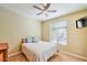 Cozy bedroom with a ceiling fan, soft lighting, and a large window for natural light at 11640 N Tatum Blvd # 1095, Phoenix, AZ 85028