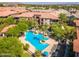 Aerial view of the community pool area with palm trees, lounge chairs, and blue umbrellas at 11640 N Tatum Blvd # 1095, Phoenix, AZ 85028