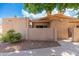 Tan single-story home features a pergola entrance, desert landscaping and a gated front patio at 1217 N Miller Rd # 23, Scottsdale, AZ 85257