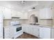 Bright kitchen with white cabinets, appliances, and a neutral countertop offers a clean and functional space at 1217 N Miller Rd # 23, Scottsdale, AZ 85257