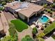 Aerial view of the home with a backyard featuring a pool, spa, built-in outdoor kitchen, and turf lawn at 12976 W Plum Rd, Peoria, AZ 85383