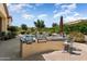 Outdoor kitchen with built-in grill, counter space, and seating area overlooking the pool and backyard at 12976 W Plum Rd, Peoria, AZ 85383
