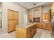 Kitchen with stainless steel appliances, custom wood cabinets, granite counters and large center island at 12976 W Plum Rd, Peoria, AZ 85383