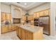 Well-equipped kitchen with stainless steel appliances, custom wood cabinets, and large center island at 12976 W Plum Rd, Peoria, AZ 85383