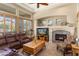 Comfortable living room features a fireplace, leather sofa, and large windows with shutters at 12976 W Plum Rd, Peoria, AZ 85383