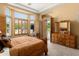 Comfortable main bedroom with wood-look shutters, private access to yard, and wooden dresser at 12976 W Plum Rd, Peoria, AZ 85383