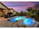 Beautiful backyard pool and spa area with rock waterfall feature and lush desert landscaping at 12976 W Plum Rd, Peoria, AZ 85383
