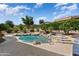 Backyard oasis featuring a freeform pool with rock waterfall and spa, surrounded by lush landscaping at 12976 W Plum Rd, Peoria, AZ 85383