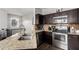 Modern kitchen with stainless steel appliances, granite countertops, and dark wood cabinetry at 1322 S Owl Dr, Gilbert, AZ 85296