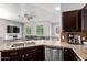Open-concept kitchen with stainless steel appliances, granite countertops, and view to the living room at 1322 S Owl Dr, Gilbert, AZ 85296