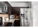 Well-equipped kitchen features stainless steel appliances, dark cabinets, and granite countertops at 1322 S Owl Dr, Gilbert, AZ 85296