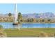Beautiful lake view featuring a fountain, framed by palm trees and distant mountains at 13636 N Hamilton Dr # 101, Fountain Hills, AZ 85268