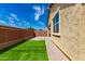 Backyard featuring artificial grass, brick pavers, and a privacy wall, perfect for outdoor enjoyment at 14355 W Valentine St, Surprise, AZ 85379