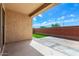 Backyard featuring a covered patio, partial artificial grass, and a brick wall for privacy at 14355 W Valentine St, Surprise, AZ 85379