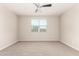 Well-lit bedroom features neutral walls, plush carpet, and a window for natural light at 14355 W Valentine St, Surprise, AZ 85379