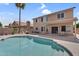 Inviting backyard featuring a refreshing pool, covered patio and lush palm trees at 14393 N 101St St, Scottsdale, AZ 85260