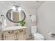 Charming powder room with vintage-style vanity, decorative mirror, and convenient toilet placement at 14393 N 101St St, Scottsdale, AZ 85260