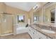 Well-lit bathroom with double sinks, granite countertop, bathtub, and glass shower at 14393 N 101St St, Scottsdale, AZ 85260