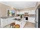 Well-lit kitchen with white cabinets, granite countertops, island, and stainless steel appliances at 14393 N 101St St, Scottsdale, AZ 85260