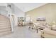 Bright open-concept living room with vaulted ceilings, staircase, and adjacent formal dining area at 14393 N 101St St, Scottsdale, AZ 85260